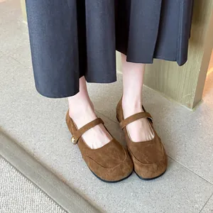 Vue détaillée des chaussures Mary Jane en daim marron de style français portées avec une jupe grise