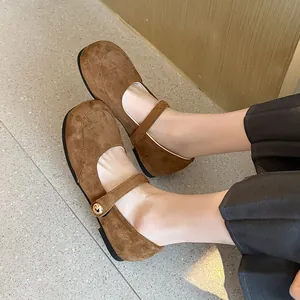 Gros plan sur d'élégantes babies Mary Jane en daim marron avec boucle décorative réglable