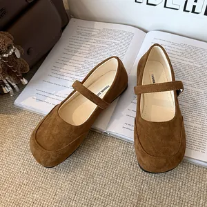 Ballerines Mary Jane en daim marron élégantes présentées sur un fond de livre ouvert