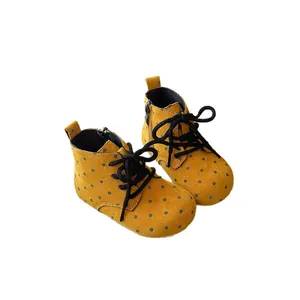 Adorable toddler girls' mustard yellow Martin boots with black polka dots and soft soles.
