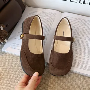 Gros-plan sur des chaussures Mary Jane en daim marron foncé avec boucle dorée élégante