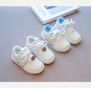 Vista detallada de zapatillas de malla para niños en blanco y azul con lindos dijes de gato.