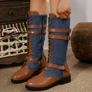 Detalle de botas altas con retazos de mezclilla y correas con hebilla en color marrón