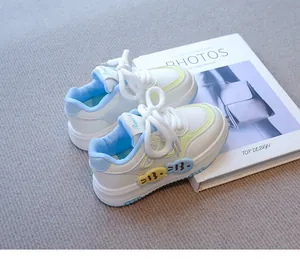 Primer plano de zapatillas blancas para niñas con detalles en azul pastel y amarillo