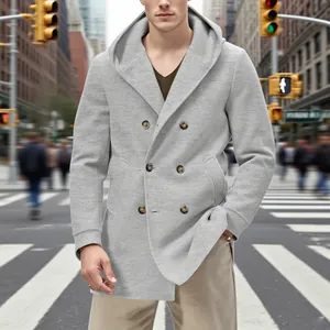 Manteau gris pour homme avec capuche et double boutonnage dans un cadre urbain.