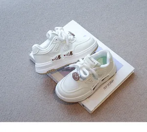 Primer plano de zapatillas blancas para niña con adornos de gato y pez