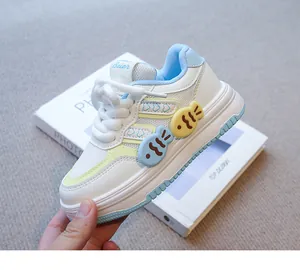 Primer plano de zapatillas blancas para niña con bonitos adornos de peces azules y amarillos
