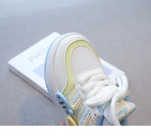 Primer plano de zapatilla blanca para niña con detalles en colores pastel y malla