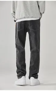 Vista posteriore dettagliata di jeans larghi da uomo grigio lavato con gamba dritta.