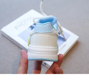 Vista posterior detallada del talón y la suela de una zapatilla blanca y azul para niña