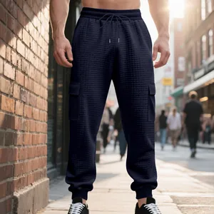 Détail rapproché du pantalon cargo en maille gaufre bleu marine pour homme en ville
