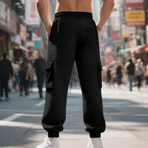 Vue arrière d'un pantalon cargo en jacquard gaufré noir pour homme avec poches