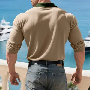 Vue arrière d'un polo à manches longues côtelé beige avec col vert au bord de la mer