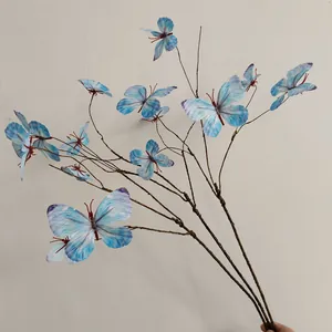 Detailansicht künstlicher blauer Schmetterlinge auf einem realistischen Zweigdekor
