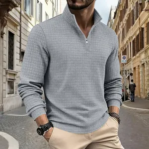 Primo piano di una felpa grigia da uomo con trama a nido d'ape e mezza zip in strada