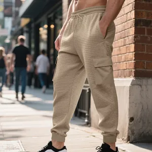 Vue détaillée du pantalon cargo jacquard lourd pour homme avec texture gaufrée beige.