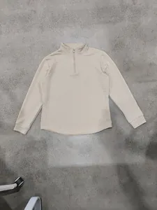 Vista dettagliata della felpa beige pesante a mezza zip con trama trapuntata