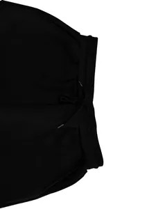 Detalle de la cintura elástica de pantalones deportivos negros con cordón ajustable.
