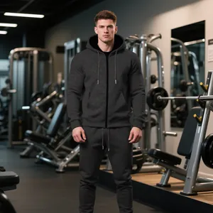 Hombre con chándal con capucha gris antracita en un gimnasio profesional moderno