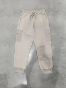 Vue détaillée du jogging beige pour hommes avec texture jacquard lourde et poches cargo.
