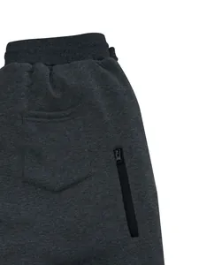 Primer plano de pantalones de chándal gris oscuro para hombre con bolsillo de cremallera.