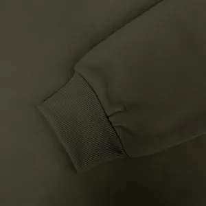 Detalle de primer plano del puño acanalado de alta calidad de una sudadera verde oliva.