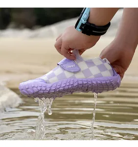 Detailed view of water dripping from a purple checkered children's wading shoe outdoors