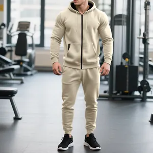 Chándal beige para hombre de felpa con sudadera con capucha y cremallera y pantalones en un gimnasio