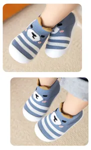 Gros plan de chaussures de bébé tricotées avec motif ours et semelles blanches