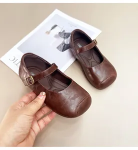 Detailed view of girls brown soft sole Mary Jane leather shoes with metal buckle strap