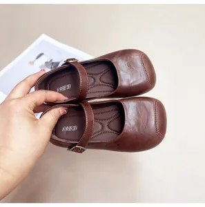 Detail view of brown leather Mary Jane shoes for girls featuring a soft sole and strap
