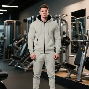 Chándal gris para hombre con sudadera con capucha y cremallera y pantalones de chándal en gimnasio.