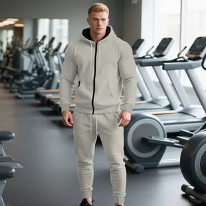 Vista completa de un chándal gris claro con capucha para hombre en un gimnasio.