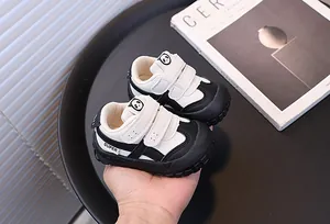 Detail view of toddler black and white sneakers with panda design and double velcro straps