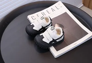 Detail view of black and white panda-style toddler sneakers with anti-kick toe caps.