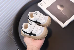 Detailed macro view of white toddler sneakers featuring black accents and a cute panda motif.