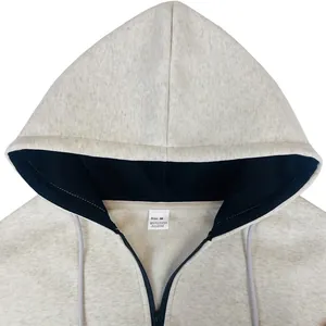 Detalle de la etiqueta de talla M en una sudadera gris con capucha y cremallera