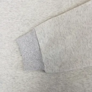 Primer plano del puño acanalado y el tejido gris jaspeado de la sudadera.