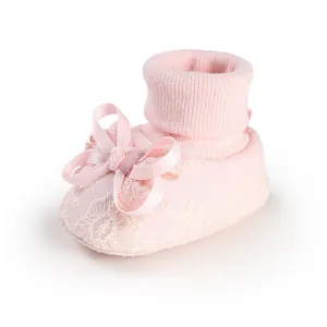 Close-up detailed view of a soft pink lace baby girl sock featuring a delicate ribbon bow