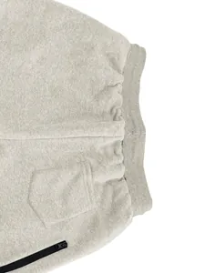 Detalle de pantalones de chándal de forro polar gris con cintura elástica y cremallera