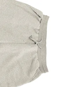 Primer plano detallado de pantalones deportivos grises con cintura elástica y cordón
