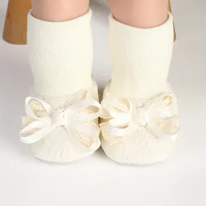 Detailed macro view of cute cream baby girl socks featuring elegant large lace bow accents