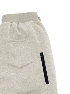 Detalle de pantalones de chándal grises para hombre con un bolsillo vertical con cremallera.