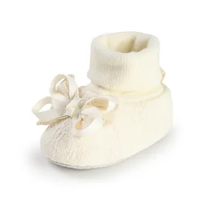 Cream baby floor socks with lace embroidery and a large bow detail for newborns