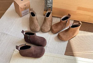 Detailweergave van drie paar retro suède enkellaarsjes voor kinderen in bruintinten.