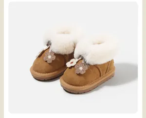 Close-up of girls' tan snow boots featuring fluffy white fur lining and knit floral accents.