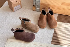 Gedetailleerde weergave van retro suède enkellaarsjes voor kinderen in diverse bruintinten.