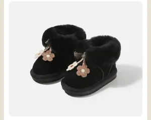 Detailed macro view of toddler girls black snow boots with fluffy fur trim and flowers