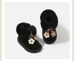 Detailed shot of girls' black snow boots with warm fur lining and floral decor