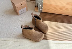 Gedetailleerde weergave van vintage bruine suède kinderlaarzen met een zijrits